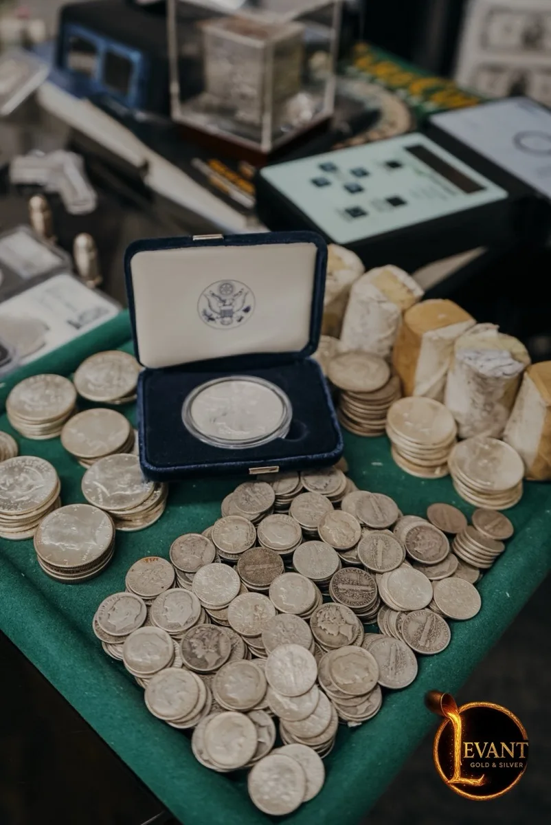 Silver dollars and coins spread on felt